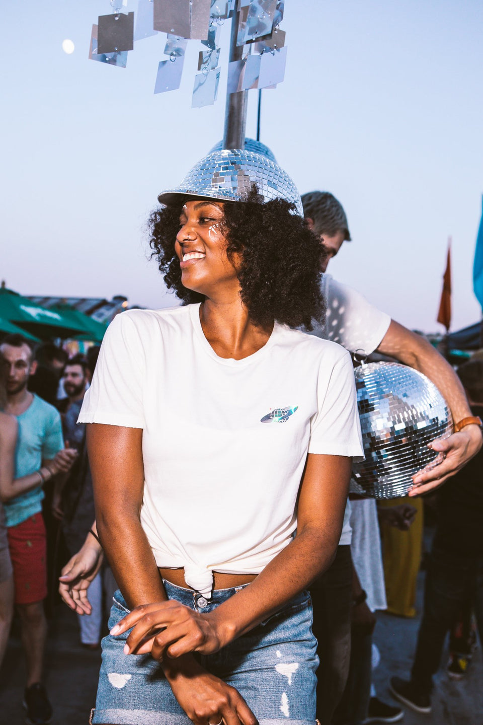 Female model wearing a Thousand Deep Planet Disco iridescent white shirt, while dancing. Photo taken on rooftop at Lightning Society in Brooklyn, New York